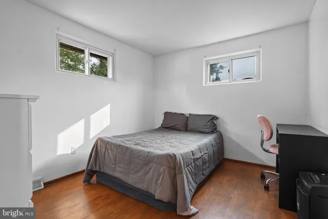 a bedroom with a bed wooden floor and a window