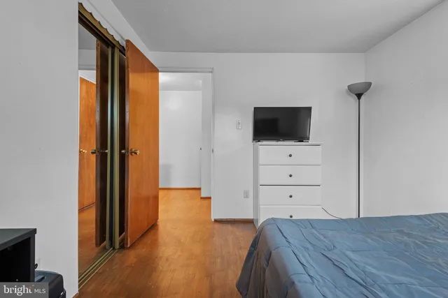 a bedroom with a bed and wooden floor