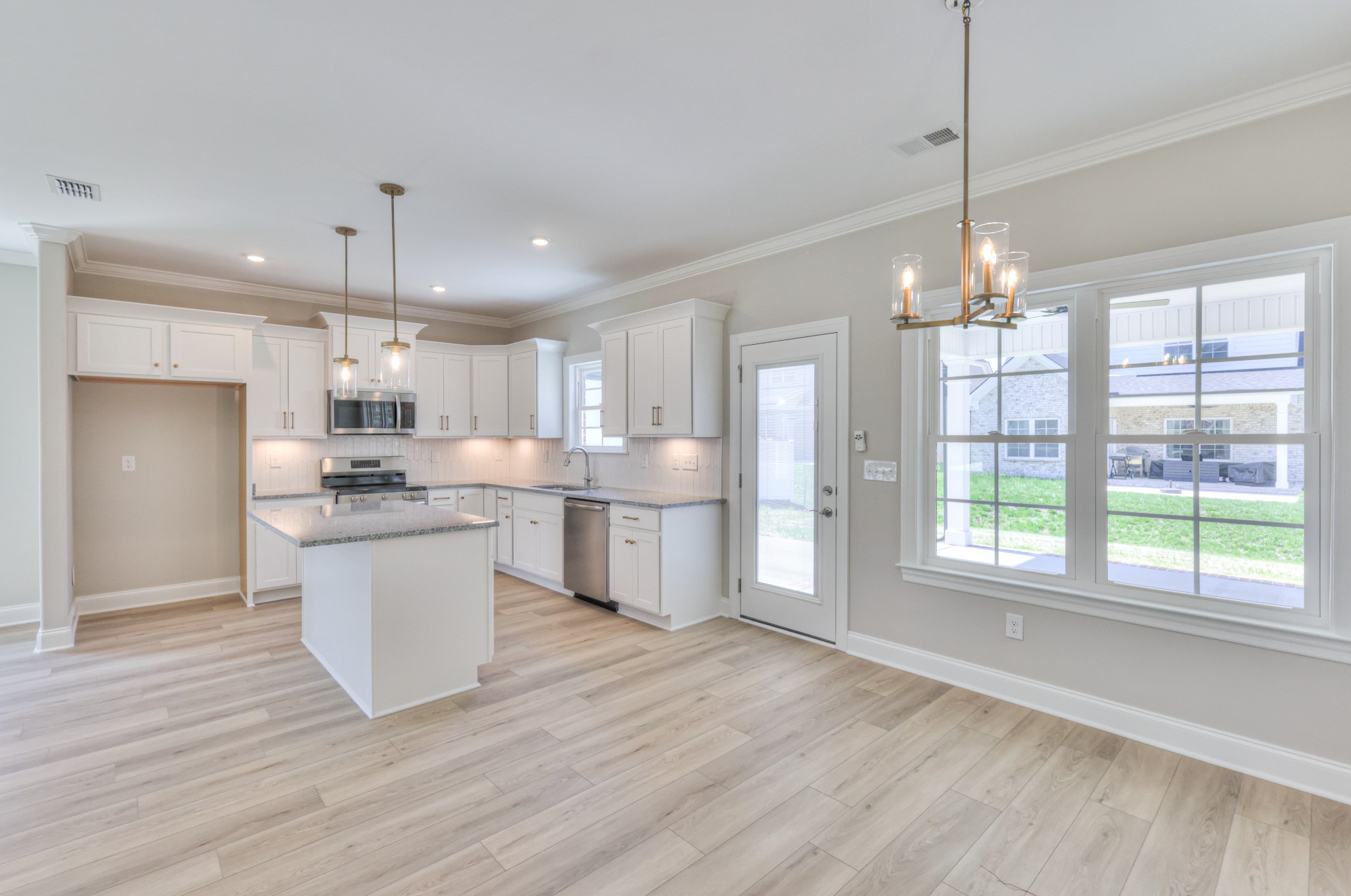 437 Ruby Oaks Lane Murfreesboro, TN 37128 - Photo 14 of 38 a kitchen with stainless steel appliances granite countertop a refrigerator a sink dishwasher a stove and white countertops with wooden floor