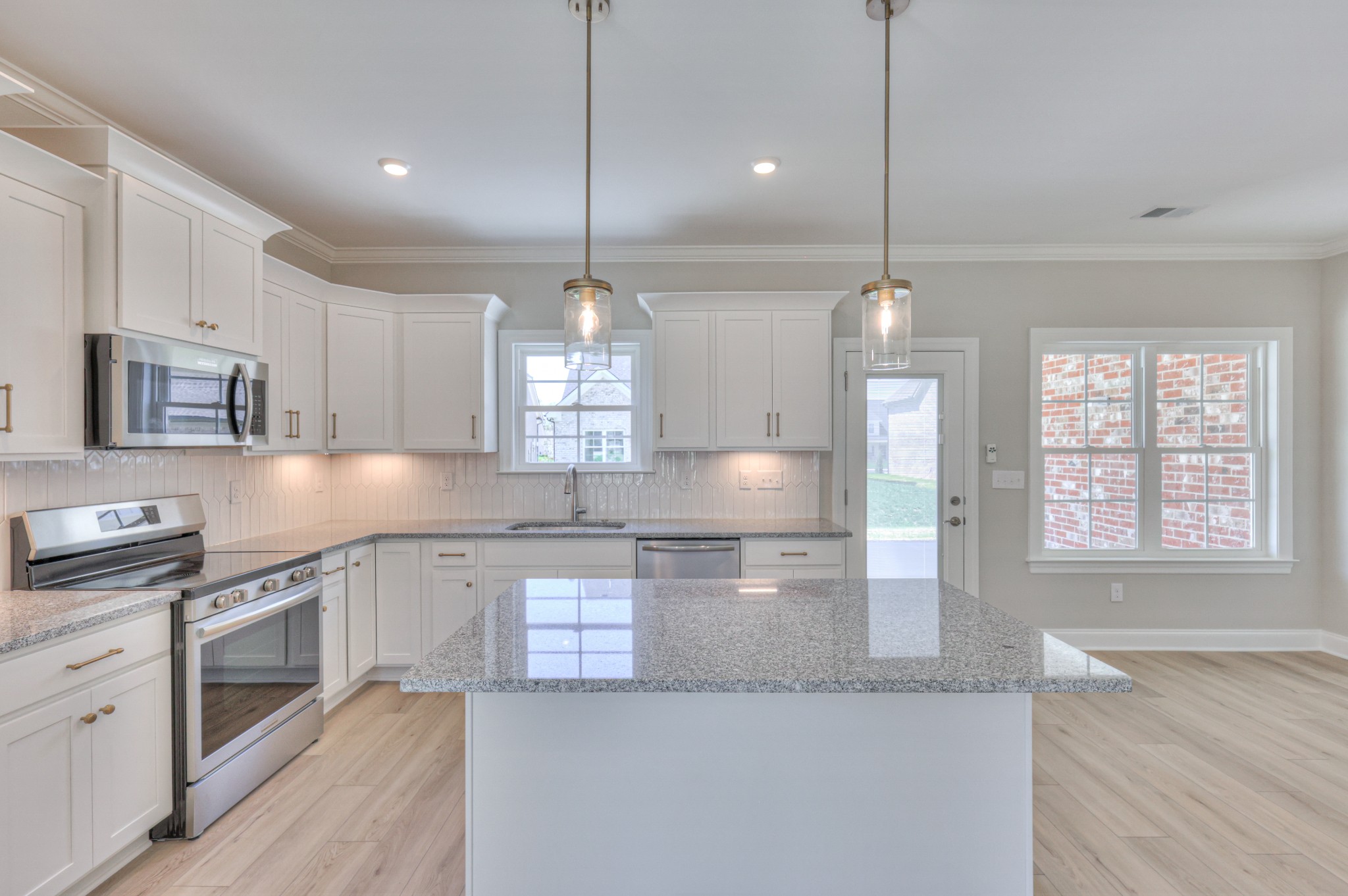 437 Ruby Oaks Lane Murfreesboro, TN 37128 - Photo 9 of 38 a large kitchen with granite countertop a stove a sink a center island and stainless steel appliances
