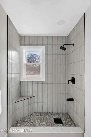 a view of an empty room with wooden floor and window