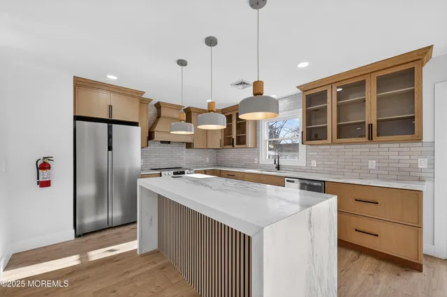 a kitchen with stainless steel appliances granite countertop a refrigerator a sink and a stove