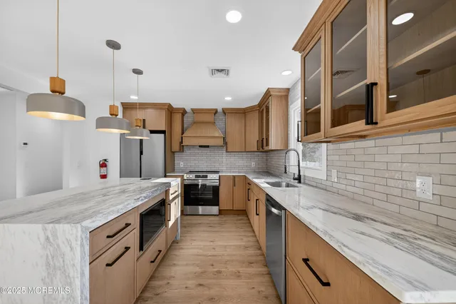 a kitchen with stainless steel appliances granite countertop a sink and stove
