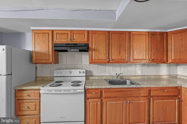 a kitchen with granite countertop cabinets and white appliances