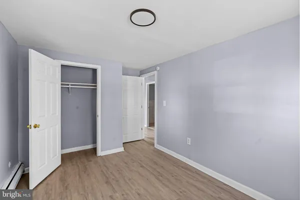 an empty room with wooden floor and mirror