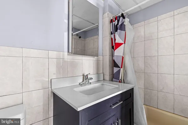 a bathroom with a sink vanity and shower