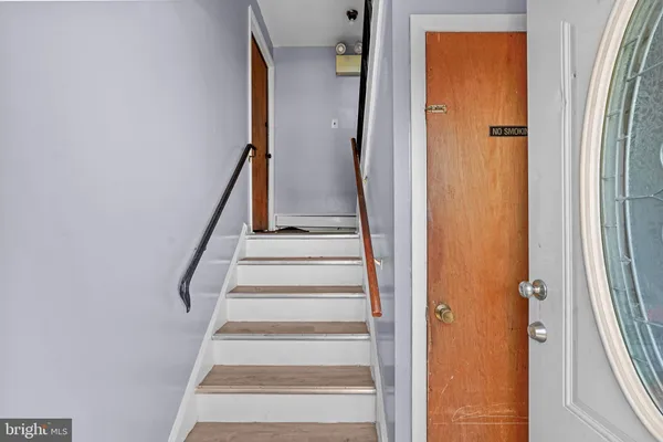 a view of staircase with wooden floor and door