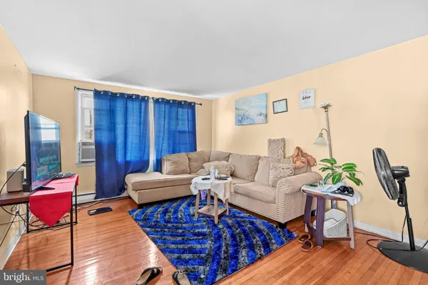 a living room with furniture a flat screen tv and a floor to ceiling window