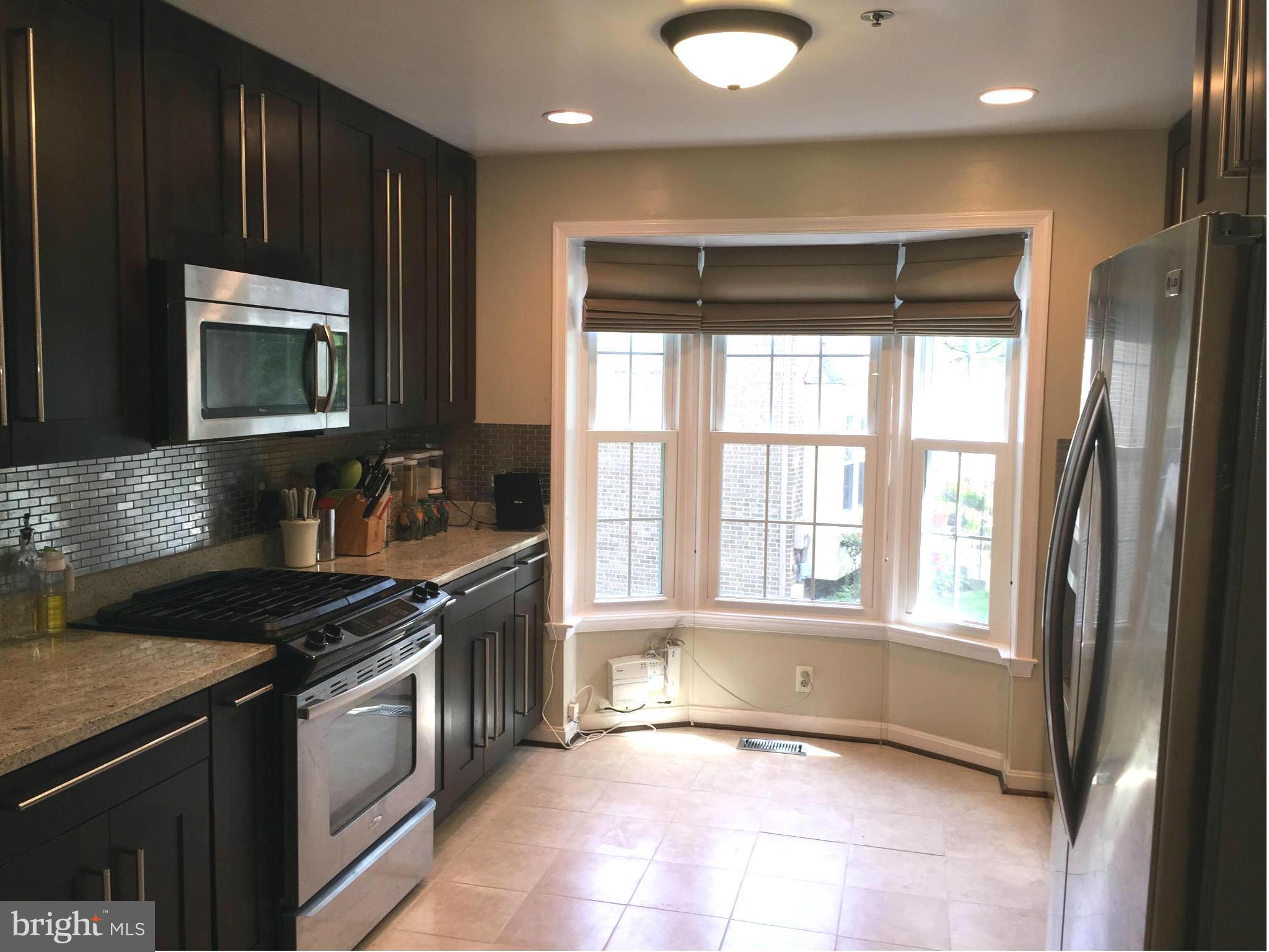 2617 Chivalry Court Silver Spring, MD 20902 - Photo 2 of 20 a kitchen with stainless steel appliances granite countertop a stove a sink and a microwave