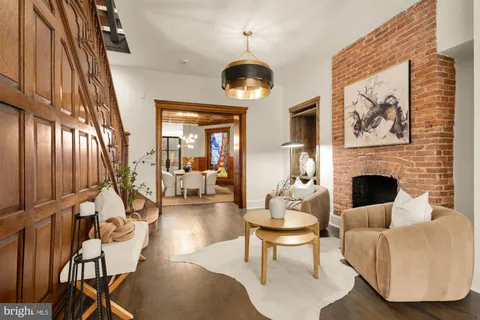 a living room with furniture a fireplace and a chandelier