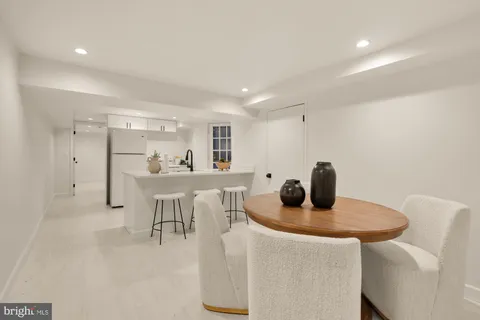 a kitchen with stainless steel appliances a table and chairs in it