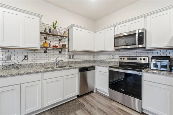 a kitchen with cabinets stainless steel appliances and a sink