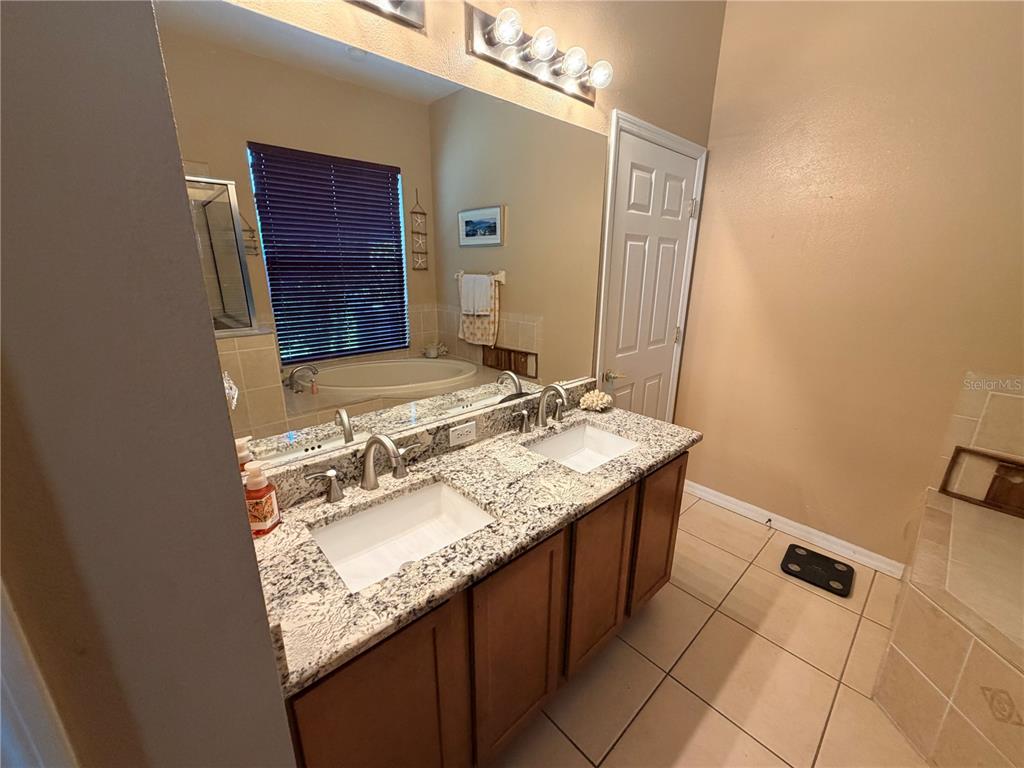 13250 Mandalay Place Spring Hill, FL 34609 - Photo 14 of 28 a bathroom with a granite countertop sink and a mirror