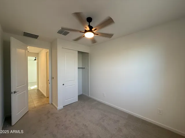 an empty room and chandelier fan