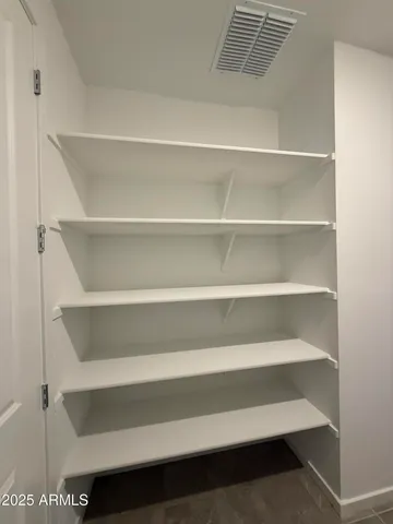 a view of walk in closet with empty racks