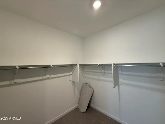 a view of walk in closet with empty racks