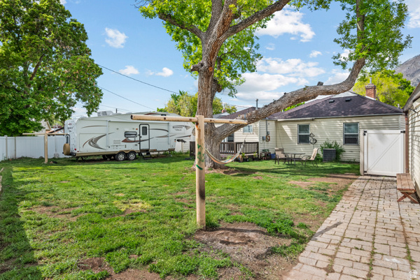 88 East C Street Springville, UT 84663 - Photo 29 of 32 Expansive backyard featuring a mature shade tree, a paver pathway, and a white privacy fence