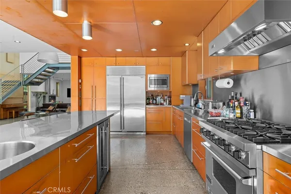 a kitchen with stainless steel appliances granite countertop a sink a stove and a refrigerator