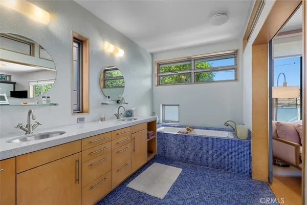 a spacious bathroom with a mirror sink and toilet