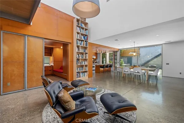 a living room with couches and kitchen view with wooden floor