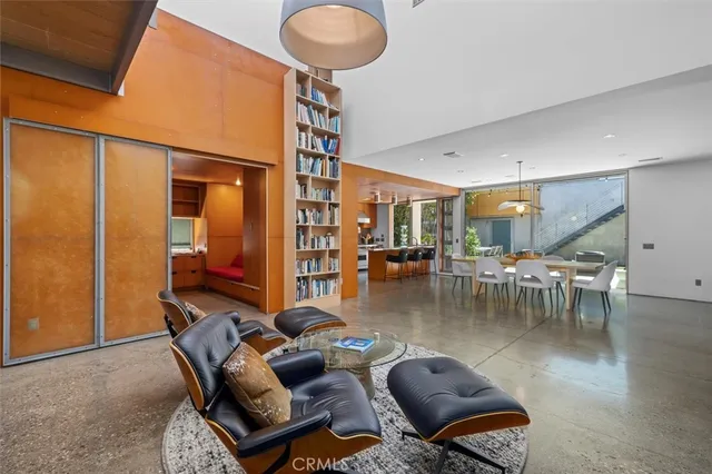 a living room with couches and kitchen view with wooden floor