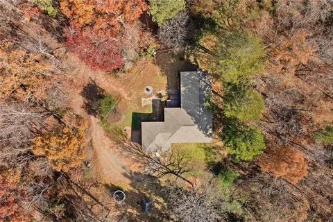 an aerial view of a house with yard and trees