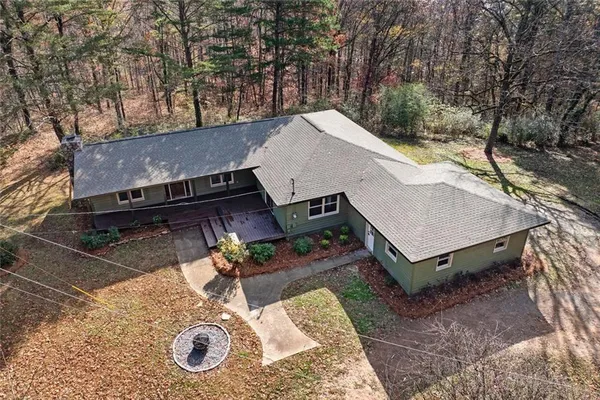 an aerial view of a house with yard and seating space