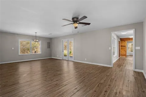 a view of empty room with wooden floor and window