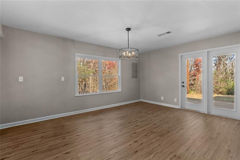 345 Roland Drive Canton, GA 30114 - Photo 27 of 44 an empty room with wooden floor chandelier and windows