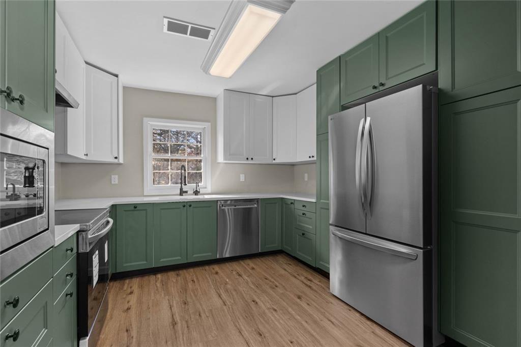 345 Roland Drive Canton, GA 30114 - Photo 31 of 44 a kitchen with stainless steel appliances a refrigerator and a sink