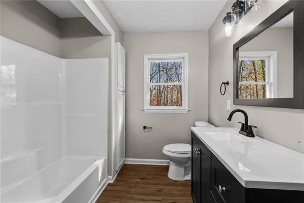 a bathroom with a sink a toilet and a mirror