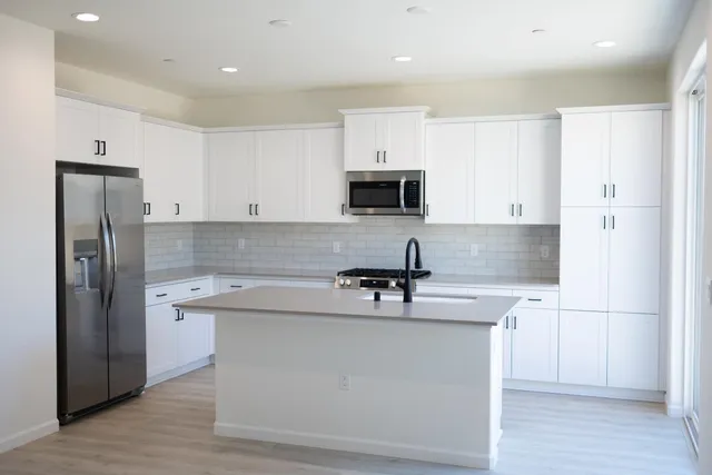 a kitchen with stainless steel appliances a refrigerator stove microwave and sink