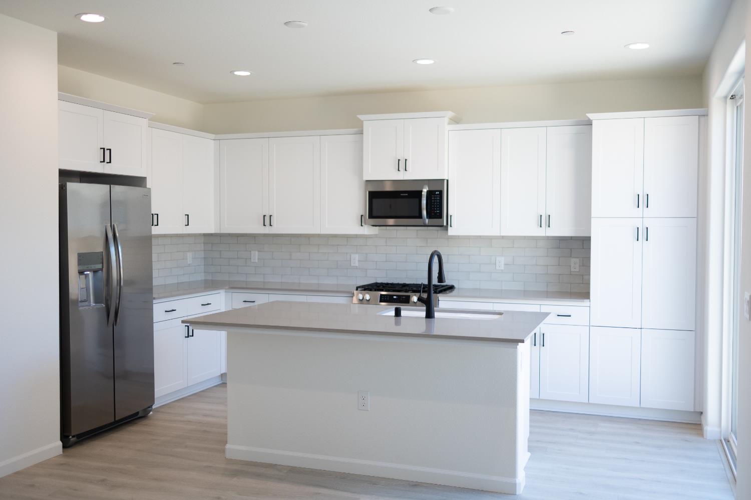 696 Grace Way Madera, CA 93636 - Photo 2 of 19 a kitchen with stainless steel appliances a refrigerator stove microwave and sink