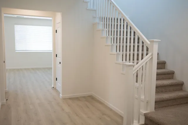 a view of staircase with railing and white walls