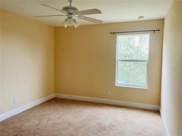 an empty room with a window and a fan
