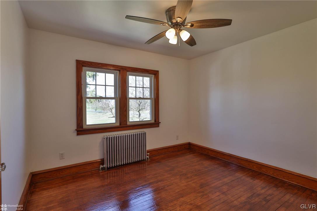 665 Point Phillips Road Bath, PA 18014 - Photo 33 of 39 an empty room with wooden floor chandelier fan and windows