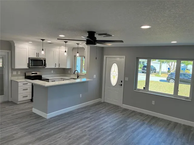 a kitchen with stainless steel appliances granite countertop a stove a sink and a microwave