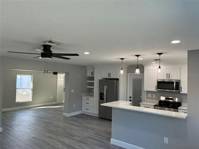 a view of kitchen with sink microwave and refrigerator