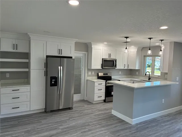 a kitchen with a refrigerator and a stove top oven