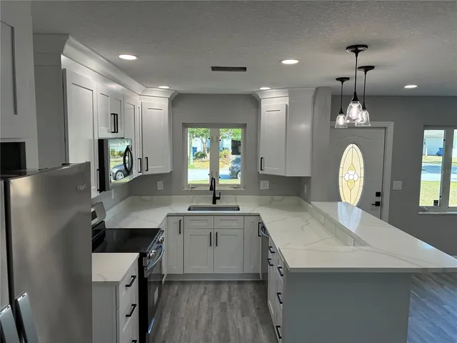 a kitchen with kitchen island a sink stove and refrigerator
