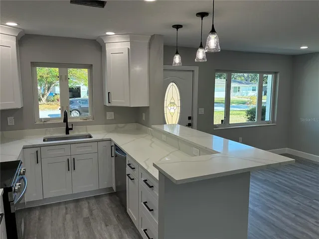 a kitchen with sink cabinets and wooden floor