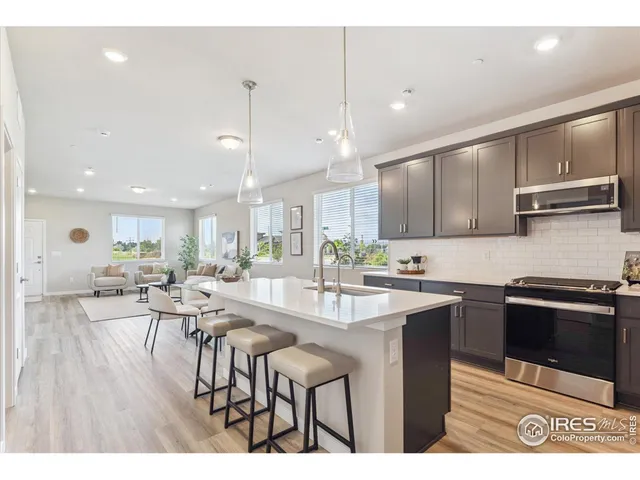 a kitchen with stainless steel appliances granite countertop a stove a sink a microwave a center island and furniture