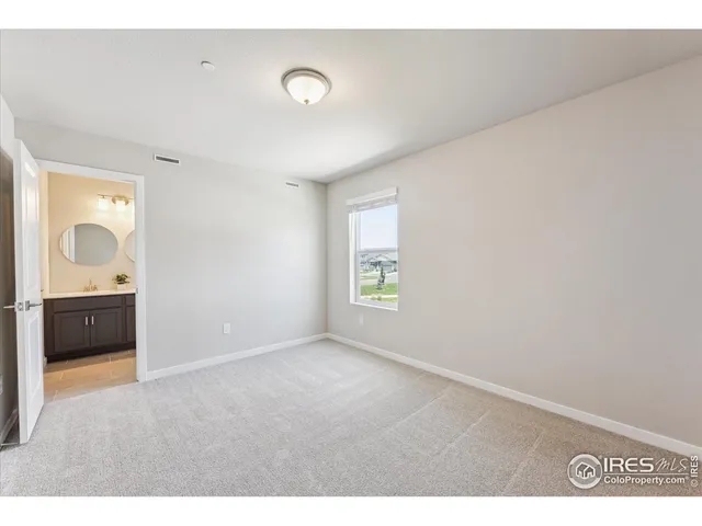 a bathroom with a toilet a sink a mirror and wooden floor