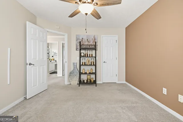an empty room with chandelier fan and closet