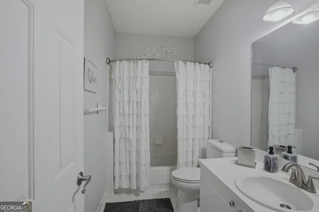 a bedroom with a bed couch and a potted plant