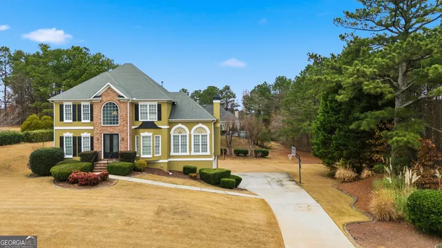 a front view of a house with a yard and potted plants