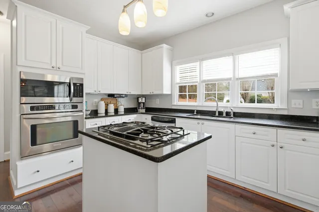 a kitchen with white cabinets and appliances