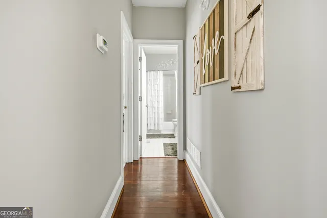a view of a hallway with wooden floor and entryway