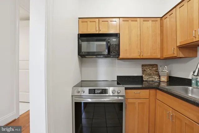 a kitchen with stainless steel appliances granite countertop a stove a microwave and a sink