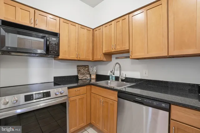 a kitchen with stainless steel appliances granite countertop a sink stove and microwave